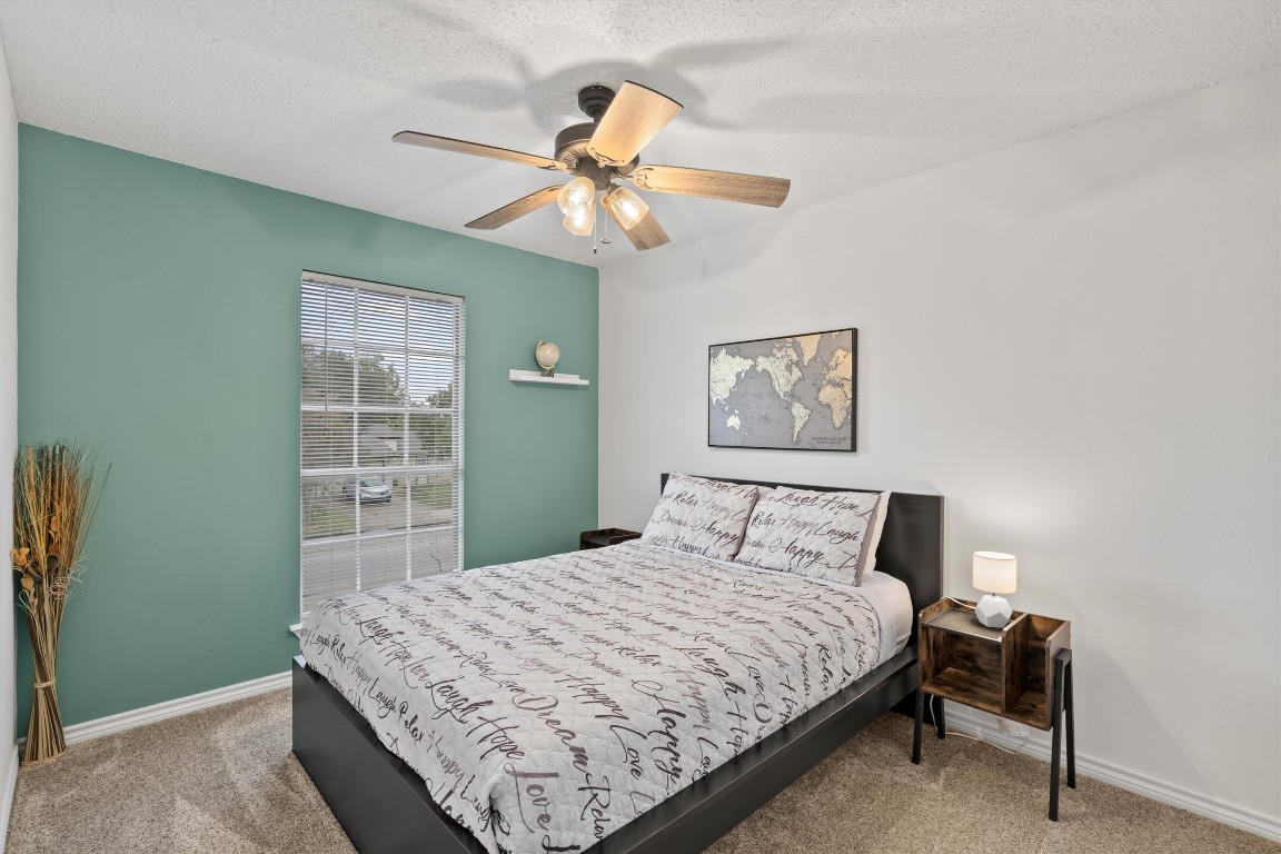 405 East Logan Street Round Rock, TX 78664 - Photo 19 of 23 a bedroom with a bed and a chandelier