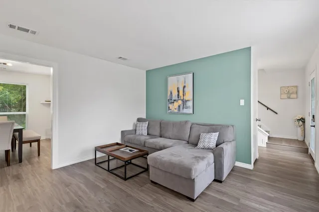 a living room with furniture and a wooden floor