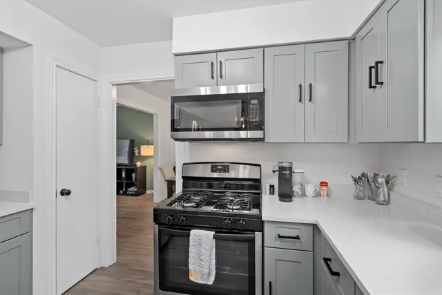 a kitchen with stainless steel appliances granite countertop a stove a microwave and cabinets