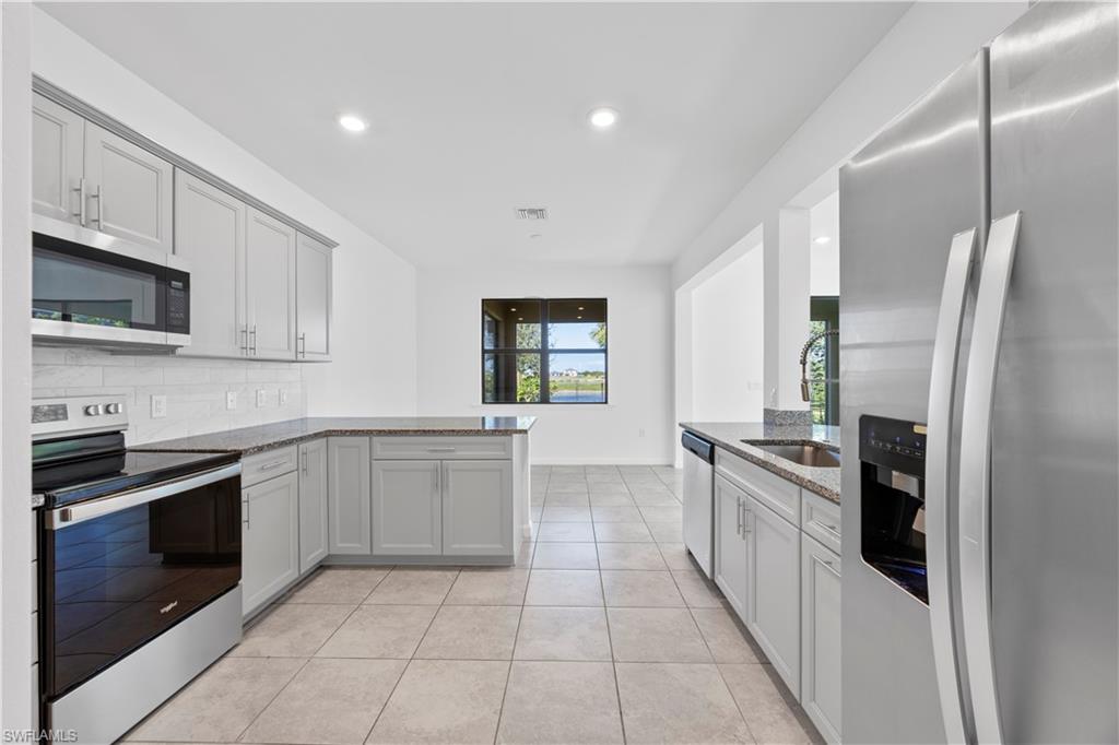 4583 Lamaida Lane Immokalee, FL 34142 - Photo 11 of 29 a large kitchen with cabinets and stainless steel appliances