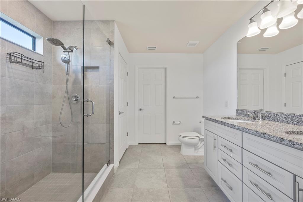 4583 Lamaida Lane Immokalee, FL 34142 - Photo 20 of 29 a spacious bathroom with a granite countertop sink a toilet and a shower