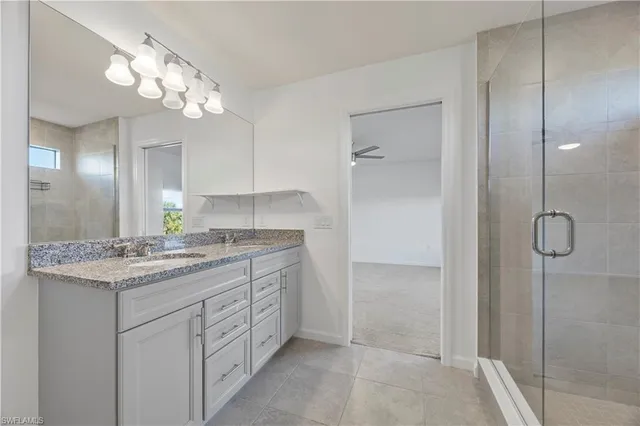 a bathroom with a granite countertop sink a mirror and a shower