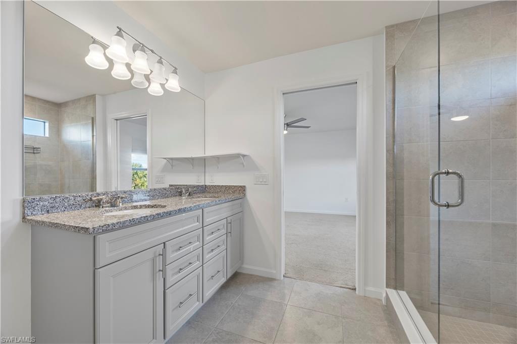 4583 Lamaida Lane Immokalee, FL 34142 - Photo 22 of 29 a bathroom with a granite countertop sink a mirror and a shower