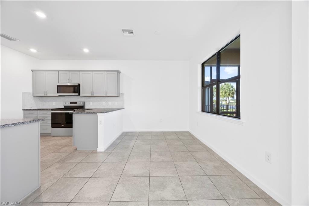 4583 Lamaida Lane Immokalee, FL 34142 - Photo 8 of 29 a kitchen with a sink a counter top space cabinets and stainless steel appliances