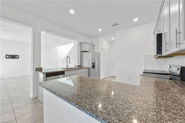 a kitchen with granite countertop a sink and a stove top oven