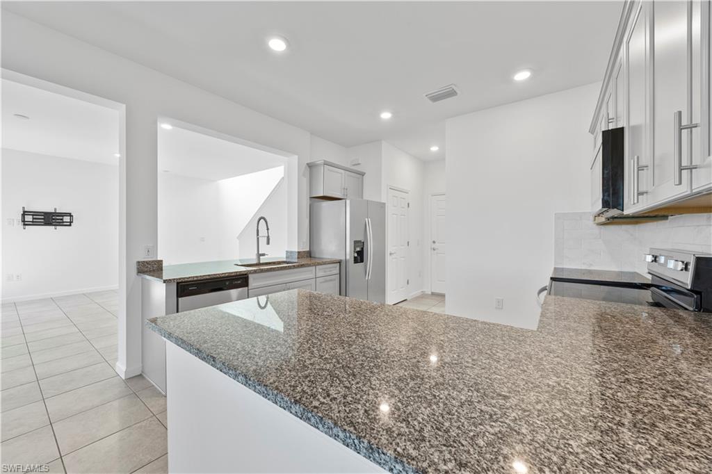 4583 Lamaida Lane Immokalee, FL 34142 - Photo 10 of 29 a kitchen with granite countertop a sink and a stove top oven