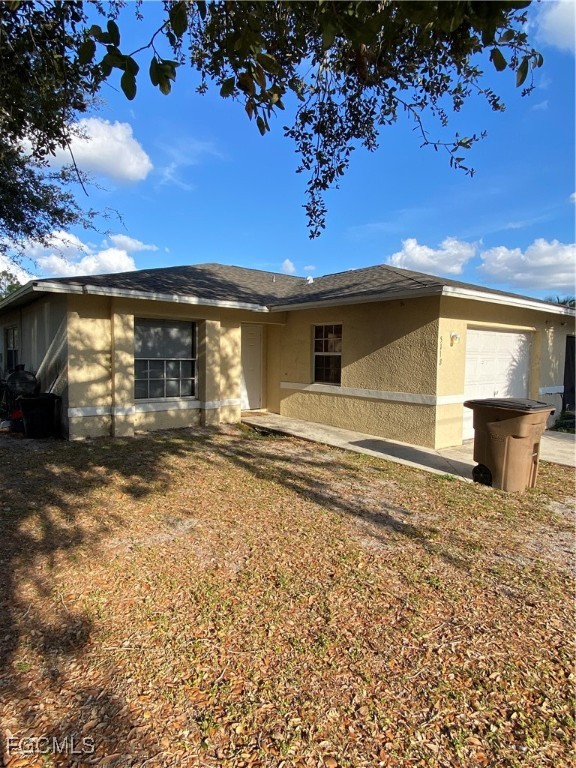 a view of a house with backyard and a tree