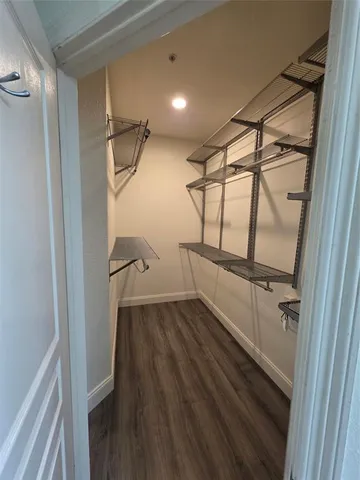 a view of walk in closet with wooden floor