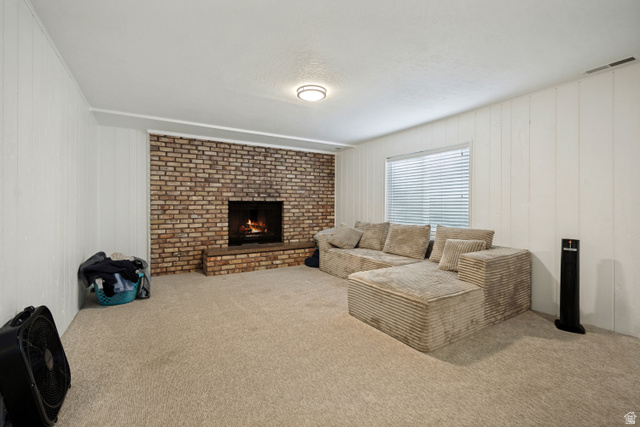 6709 Acoma Road, Unit 239 Midvale, UT 84047 - Photo 16 of 38 6711 - Basement Living Room. Brick-surround fireplace with hearth, white paneled walls, and recessed lighting