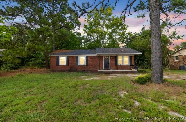 a view of a house with backyard and a sitting area