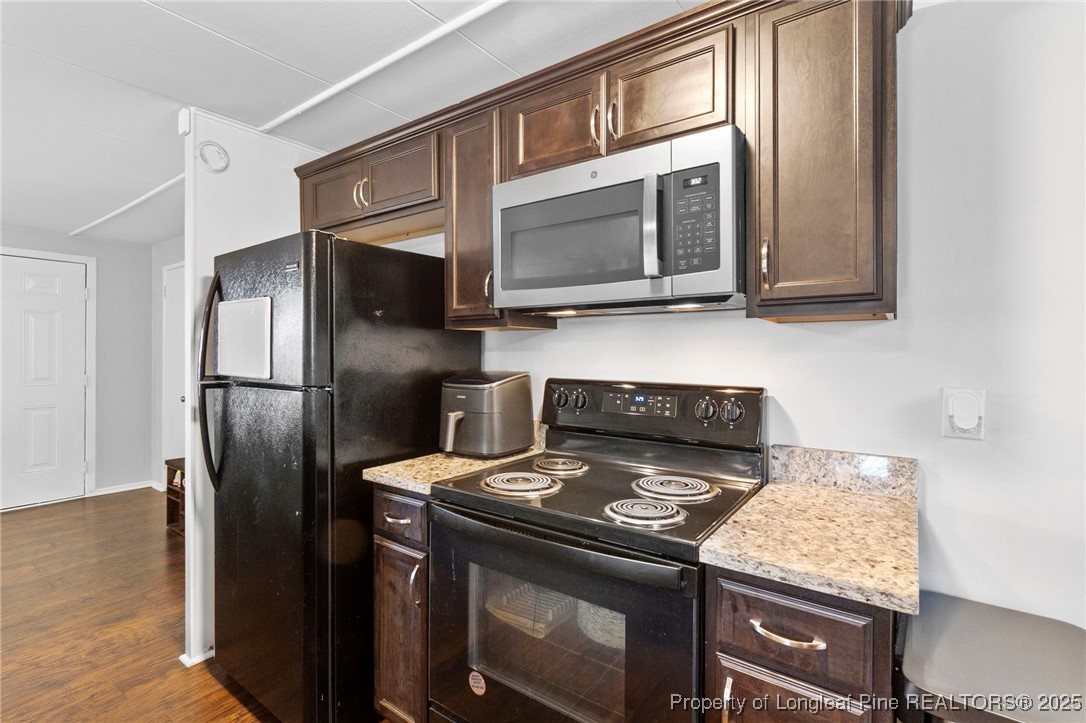 4112 Legion Road Hope Mills, NC 28348 - Photo 11 of 22 a kitchen with stainless steel appliances granite countertop a stove microwave and refrigerator
