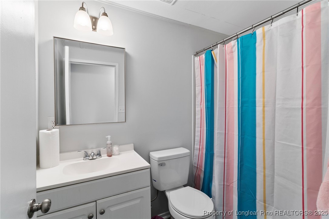 4112 Legion Road Hope Mills, NC 28348 - Photo 12 of 22 a bathroom with a sink a toilet and a mirror