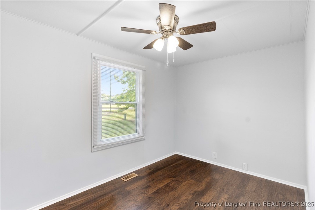 4112 Legion Road Hope Mills, NC 28348 - Photo 15 of 22 an empty room with wooden floor chandelier fan and windows