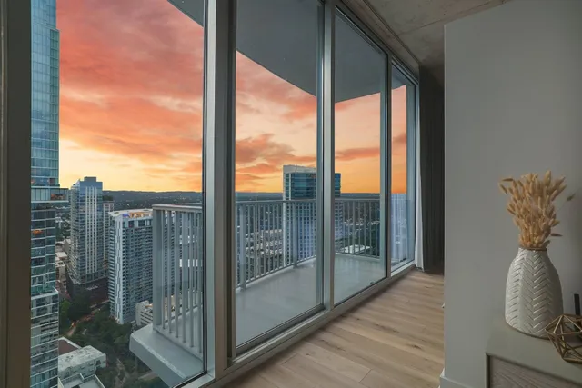 a bedroom with a large window and a balcony view