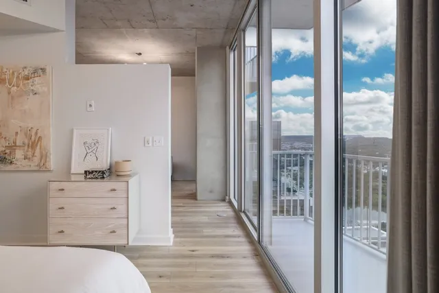 a bedroom with a large window and a bed