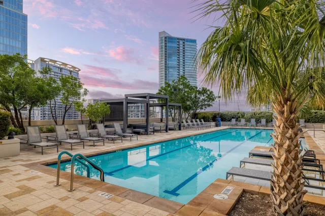a roof deck with table and chairs and potted plants