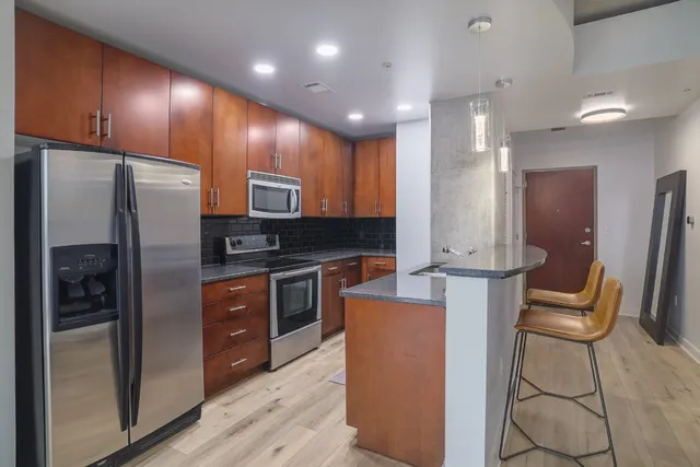 a kitchen with stainless steel appliances granite countertop a sink stove and cabinets