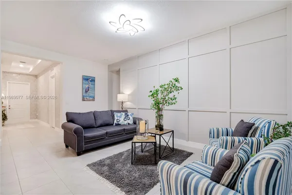 a living room with furniture potted plant and a mirror