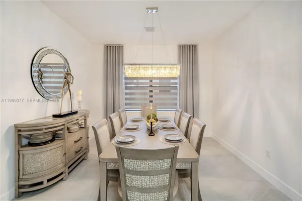 a front view of a house with a yard and potted plants