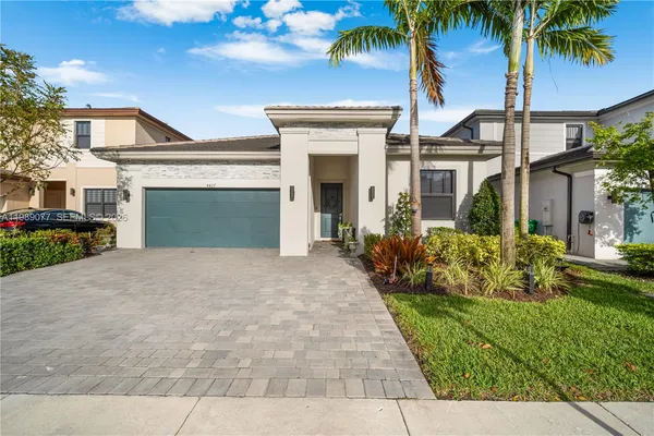 a view of a house with a yard and potted plants