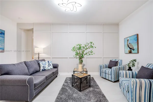 a living room with furniture flowers and a potted plant