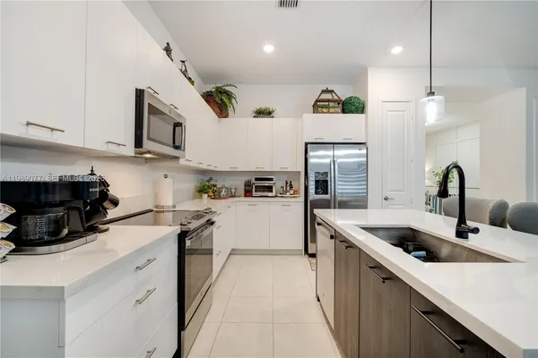 a kitchen with a sink stainless steel appliances cabinets and a counter top space