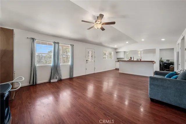 a view of a kitchen with wooden floor and a window