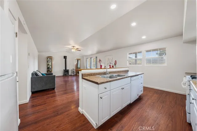 a kitchen with granite countertop a sink and wooden floor