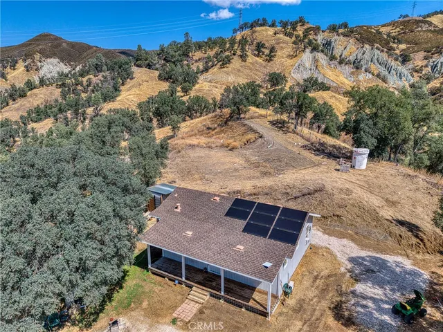 an aerial view of a house with a mountain
