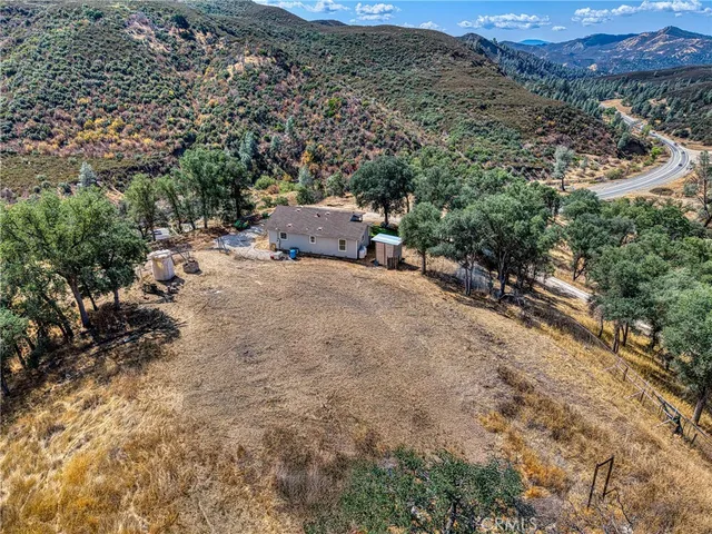 a view of a dry field with mountains in the background