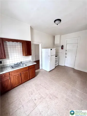 a large kitchen with a stove a sink and a refrigerator
