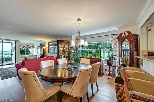 a dining room with furniture a chandelier and wooden floor