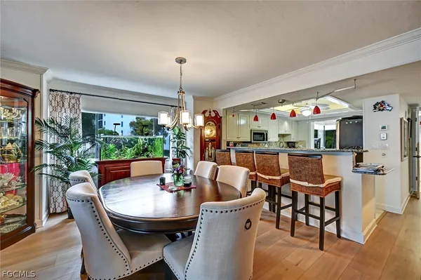a dining room with furniture a chandelier and wooden floor