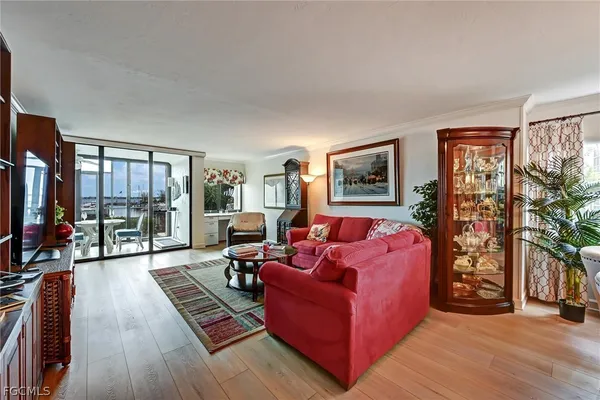 a living room with furniture a flat screen tv and a floor to ceiling window