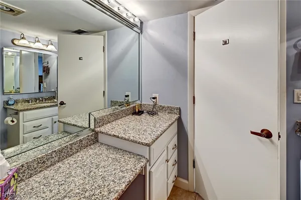 a bathroom with a granite countertop sink and a mirror