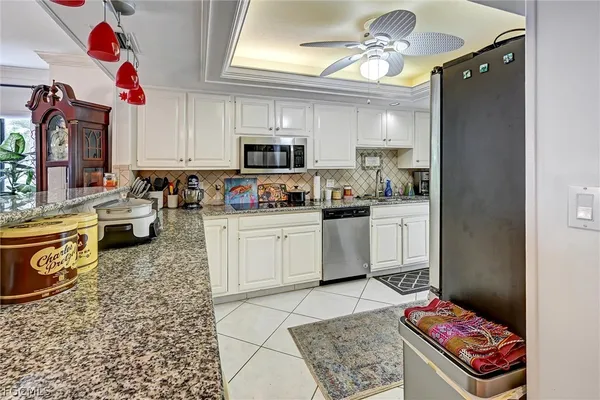 a kitchen with kitchen island granite countertop a sink cabinets stainless steel appliances and a counter top