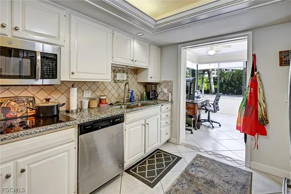 a kitchen with lots of appliances a sink and cabinets