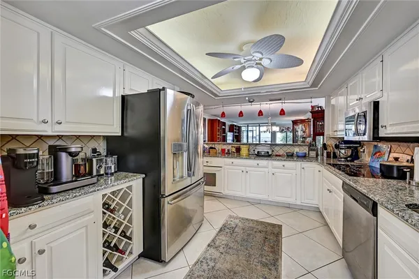 a kitchen with stainless steel appliances granite countertop a refrigerator and a stove top oven