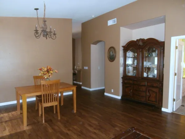 a dining room with furniture a chandelier and wooden floor