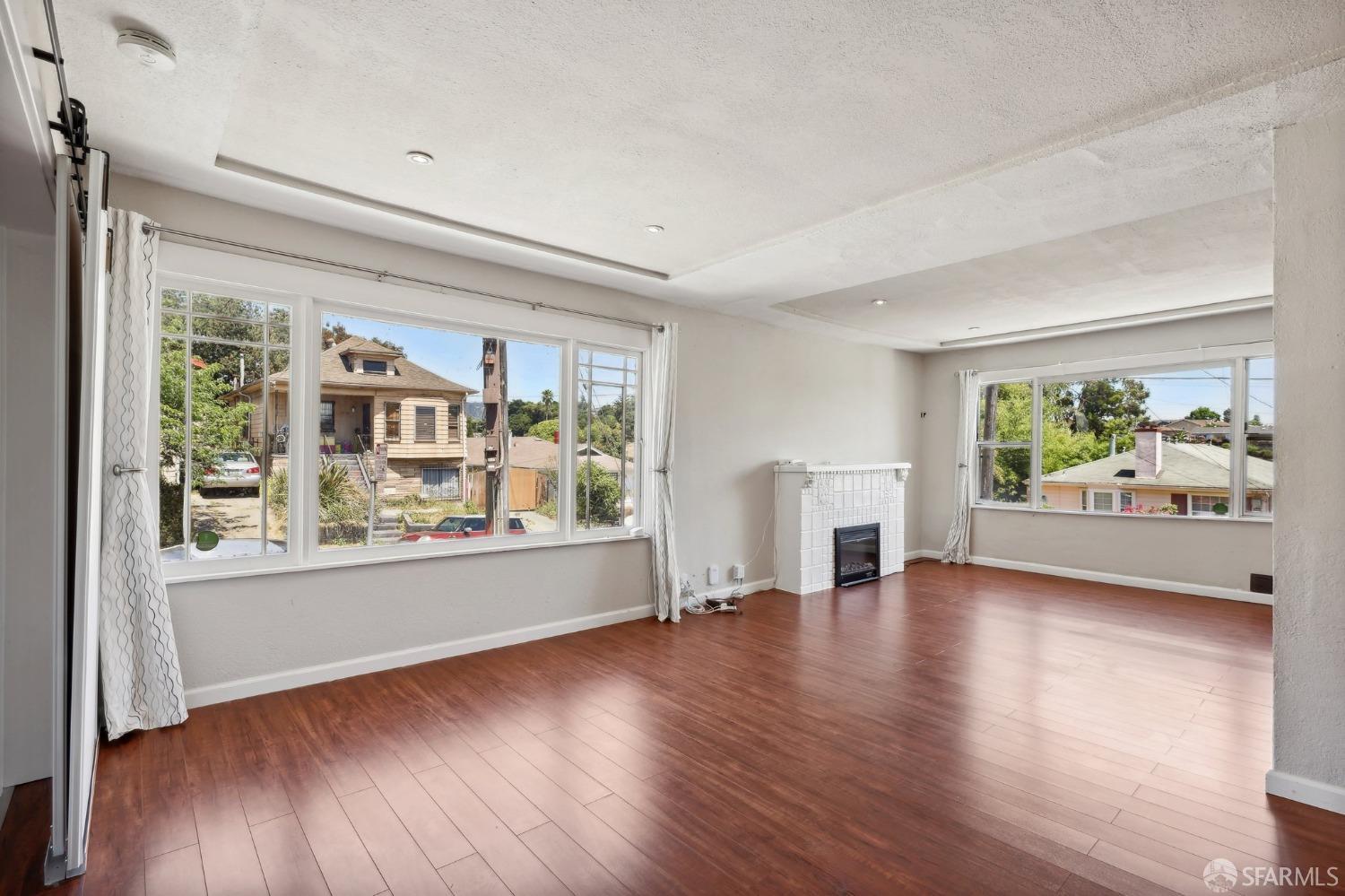 2047 36th Avenue Oakland, CA 94601 - Photo 15 of 19 an empty room with wooden floor and windows