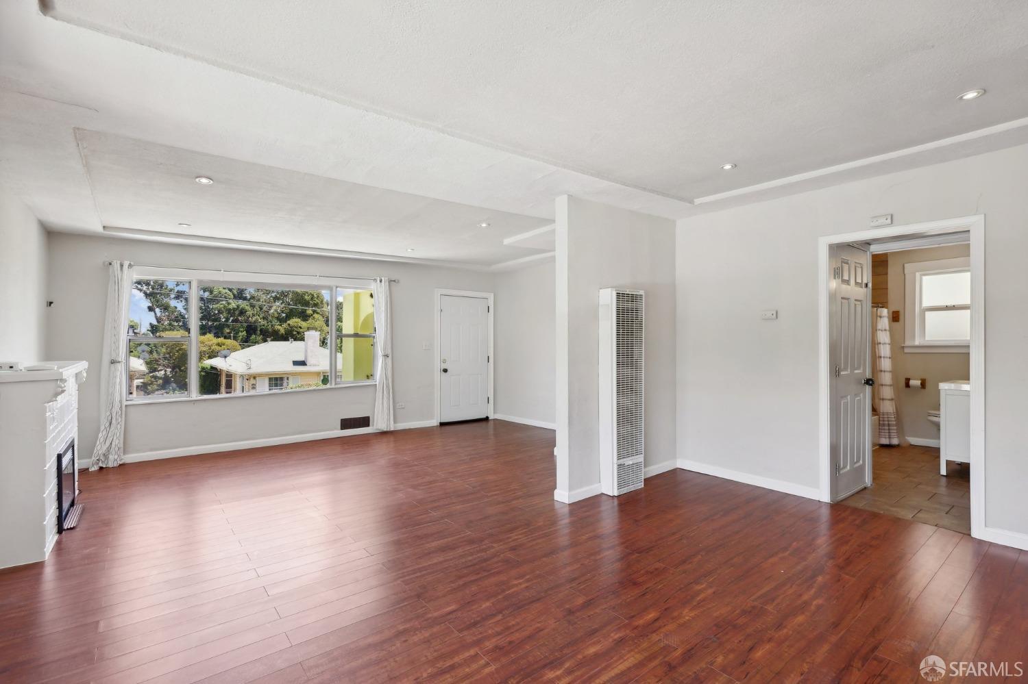 2047 36th Avenue Oakland, CA 94601 - Photo 16 of 19 an empty room with wooden floor and windows