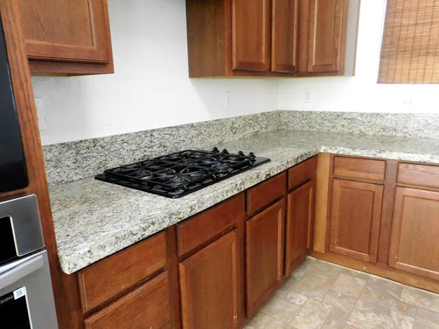 a kitchen with granite countertop cabinets and utility