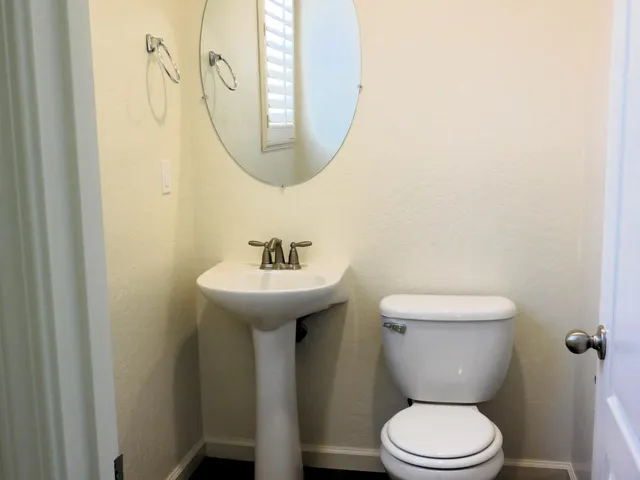 a bathroom with a toilet sink and mirror