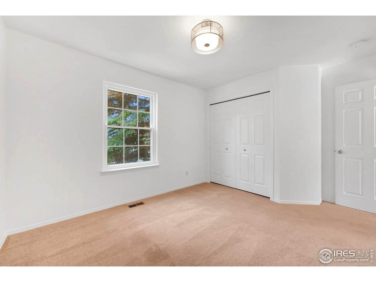 3109 Concord Way Longmont, CO 80503 - Photo 17 of 50 Main level bedroom without staging, has a nice sized closet and large tree out front for privacy