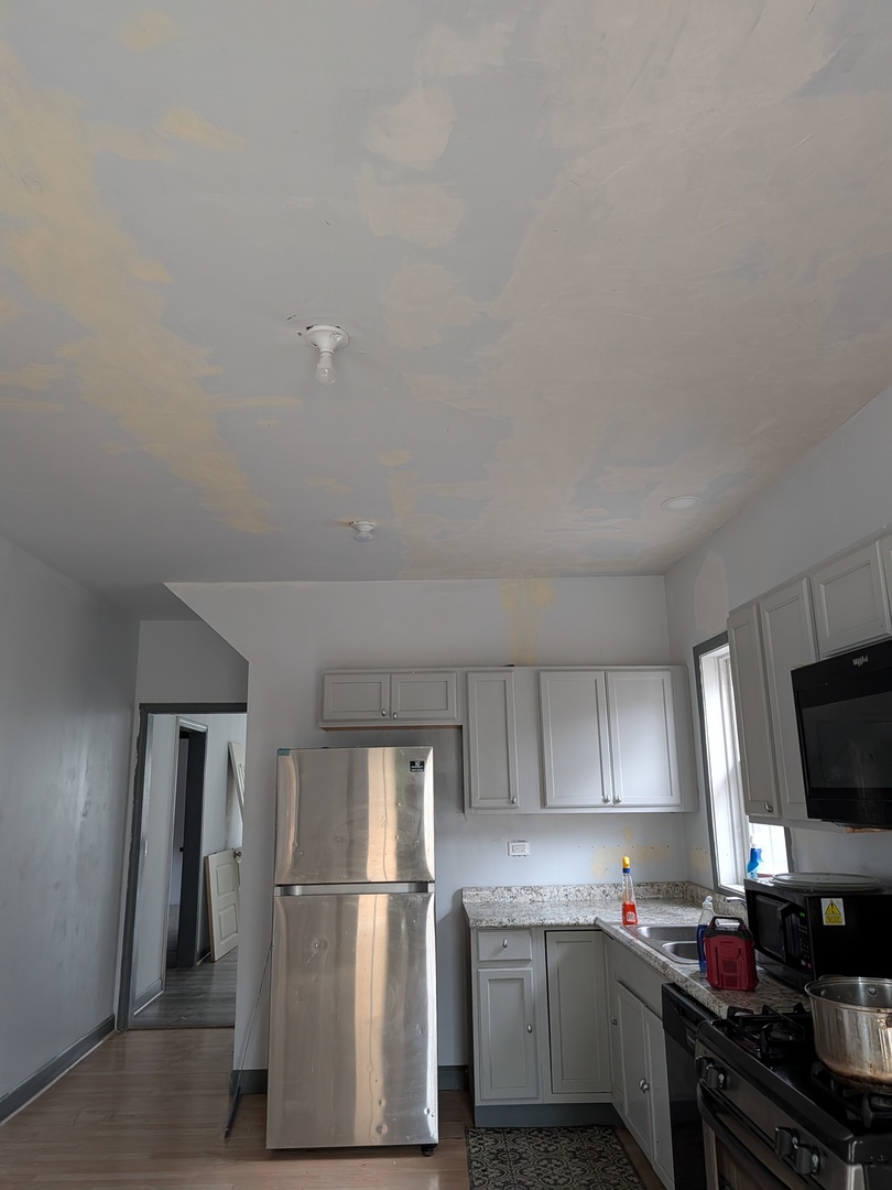 5041 West George Street Chicago, IL 60641 - Photo 5 of 11 a kitchen with a refrigerator a stove top oven a sink and dishwasher