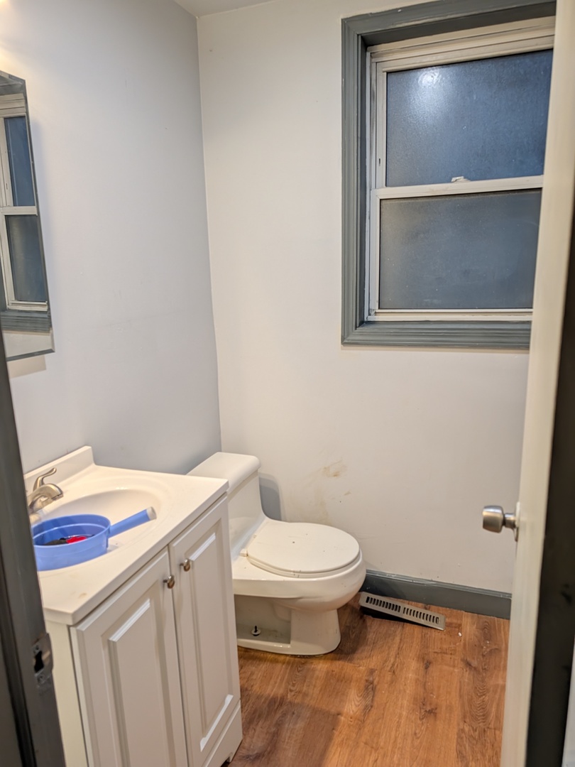 5041 West George Street Chicago, IL 60641 - Photo 9 of 11 a bathroom with a toilet sink and vanity