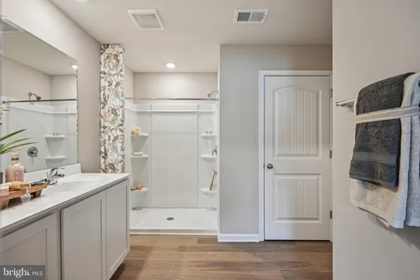 a bathroom with a double vanity sink a large mirror and shower