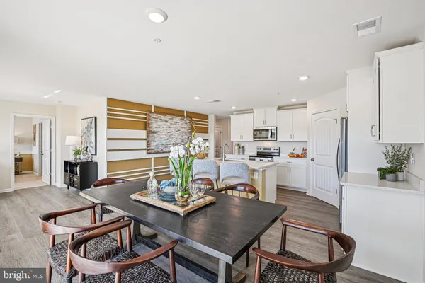 a kitchen with a dining table chairs and white appliances