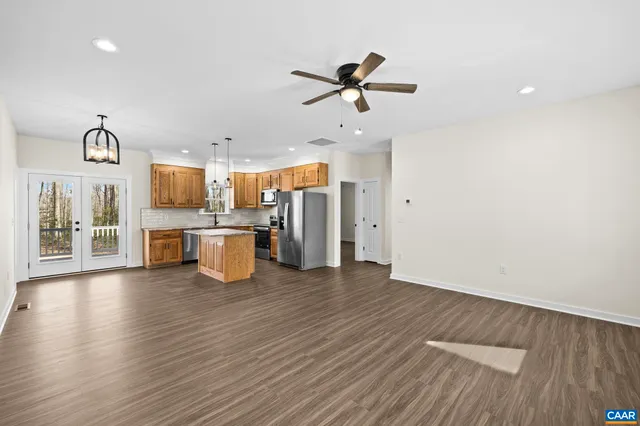 a large kitchen with stainless steel appliances granite countertop a stove a refrigerator a sink and a dishwasher with wooden floor