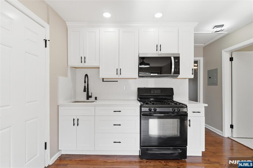 293 North Center Street, Unit 2 Orange, NJ 07050 - Photo 11 of 25 a kitchen with white cabinets and stainless steel appliances
